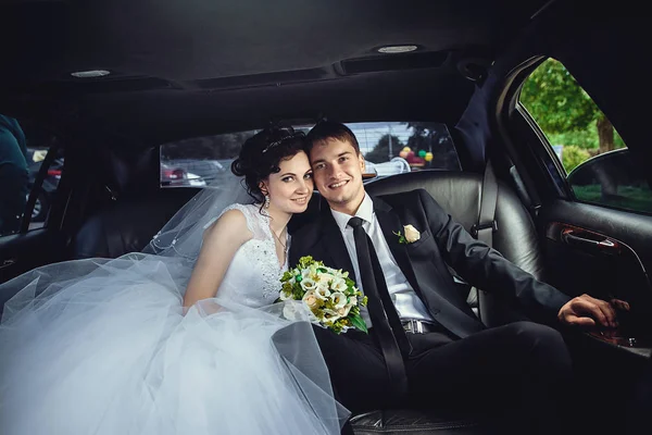 La pareja sentada en la limusina. Retrato de una hermosa joven co —  Fotos de Stock