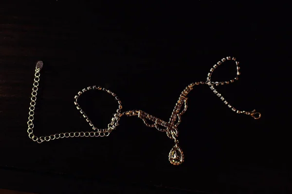 Le mot amour est disposé à partir de bijoux en or sur un fond noir — Photo