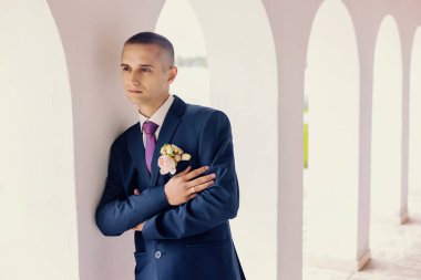 Pantolon ve bir veststylish bir iş suita adamı şık genç adam morningattractive adam duvara yaslanmış parlak roomthe adam standları mamülleri