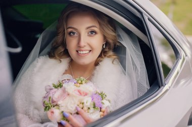 Genç gelin düğün arabada. Gelin buketi.