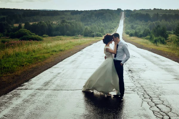 Casal de luxo fica na estrada indo para a distância e abraços — Fotografia de Stock