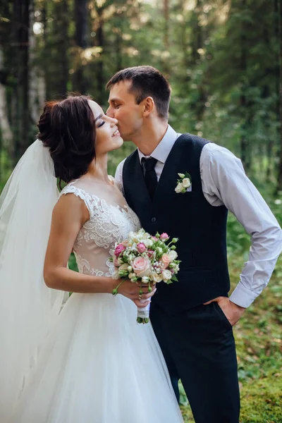 Mooi portret van gelukkige bruid en bruidegom op groene bos achtergrond — Stockfoto