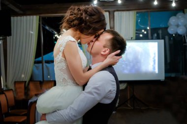 Damat gelini kollarında tutar ve onu öper