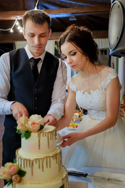 A noiva e o noivo cortaram o bolo de casamento juntos. O conceito do casamento — Fotografia de Stock