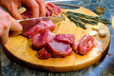 Erkek aşçı tahtadan taze et kesiyor.