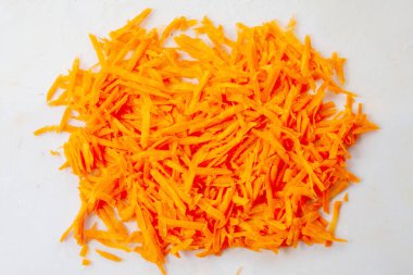 Sulu, parlak havuçlar rendelenmiş rendelenmiş, beyaz bir sırtta izole edilmiş.