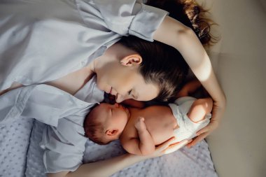 Genç bir anne ve yeni doğmuş bir çocuk yakınlarda yatıyor. Anneler Günü