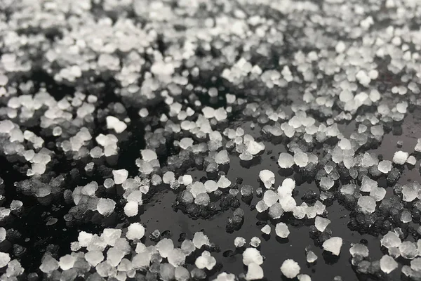 Large grains of hail on a black background. Background, texture — Stock Photo, Image