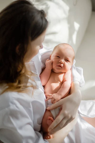 Pretty woman holding a newborn baby in her arms — Stock Photo, Image