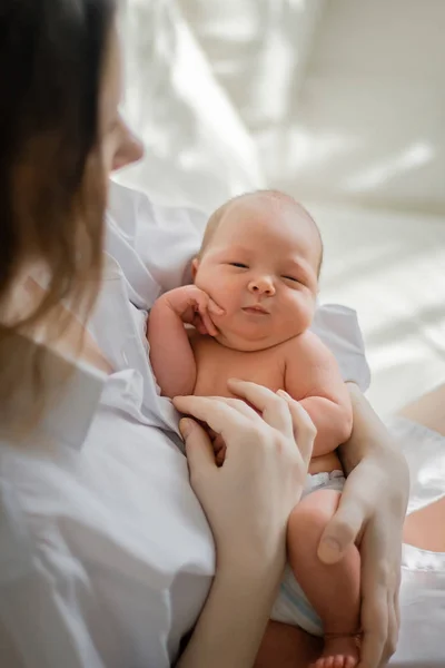 Vacker kvinna som håller ett nyfött barn i sina armar — Stockfoto