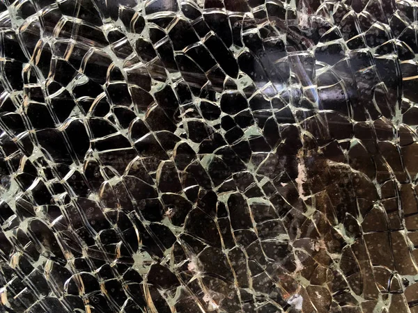 Разбитое стекло с маленькими трещинами на темном фоне. Бак текстуры Лицензионные Стоковые Изображения
