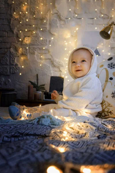 クリスマスの朝白いスーツの子供が喜びに座っている — ストック写真