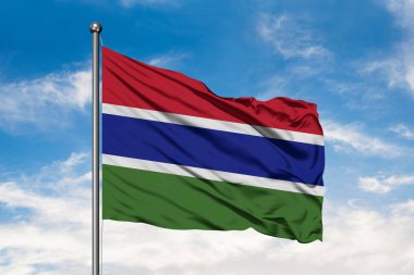 Gambiya beyaz bulutlu mavi gökyüzü karşı rüzgarda sallayarak bayrak. Gambiya bayrak.