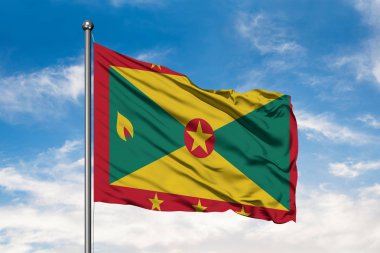 Grenada beyaz bulutlu mavi gökyüzü karşı rüzgarda sallayarak bayrak. Grenada bayrağı.