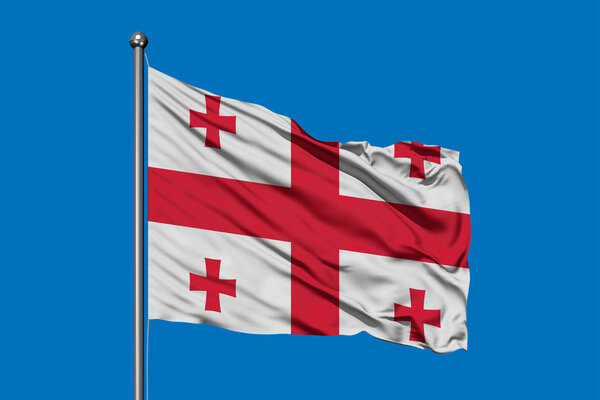 Flag of Georgia waving in the wind against deep blue sky. Georgian flag.