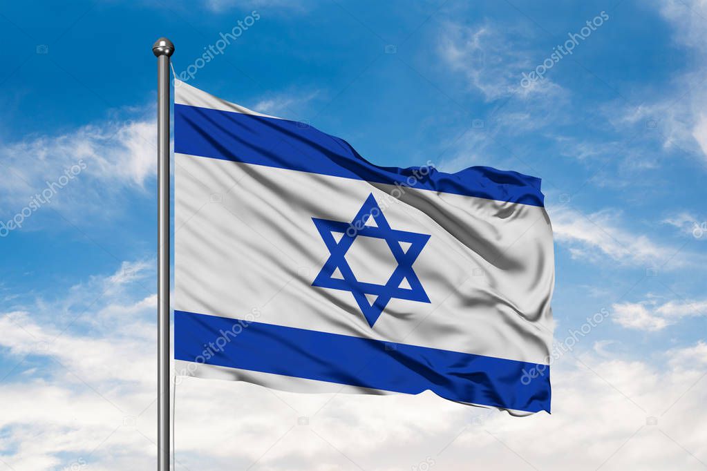 Flag of Israel waving in the wind against white cloudy blue sky. Israeli flag.