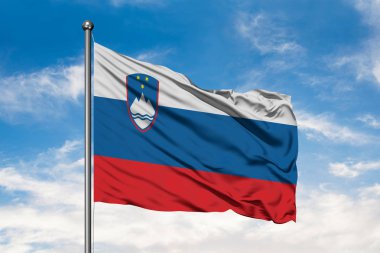 Slovenya beyaz bulutlu mavi gökyüzü karşı rüzgarda sallayarak bayrak. Slovenya bayrağı.