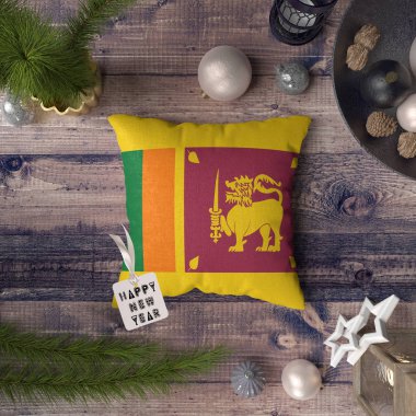 Mutlu yeni yıl etiketi ile Sri Lanka bayrağı yastık üzerinde. Noel dekorasyon konsepti üzerine güzel nesneler ile ahşap masa.