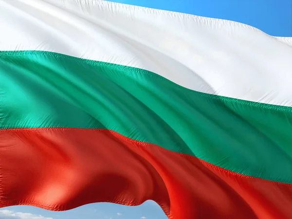 Flag of Bulgaria waving in the wind against deep blue sky. High quality fabric.