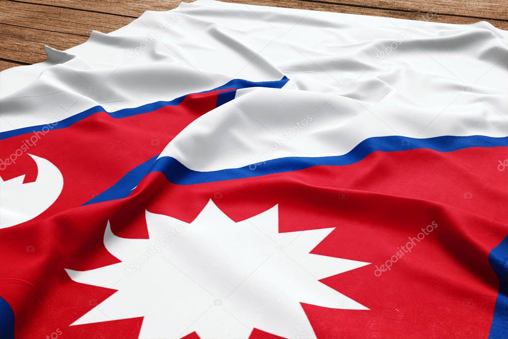 Flag of Nepal on a wooden desk background. Silk Nepalese flag top view.