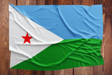 Cibuti bayrağı ahşap masa arka plan üzerinde. Buruşuk bayrak üstten görünüm.