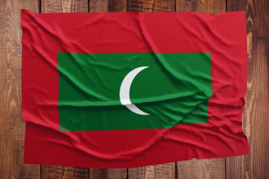 Maldivler bayrağı ahşap masa arka plan üzerinde. Buruşuk Maldivan bayrak üstten görünüm.