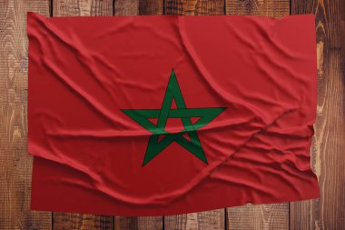 Ahşap masa arka plan üzerinde bayrak Fas. Buruşuk Fas bayrak üstten görünüm.