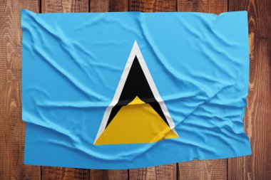 Saint Lucia bayrağı ahşap masa arka plan üzerinde. Buruşuk bayrak üstten görünüm.