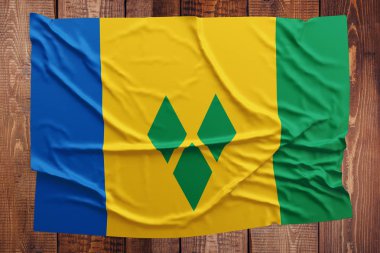 Saint Vincent ve Grenadinler bayrağı ahşap masa arka plan üzerinde. Buruşuk bayrak üstten görünüm.