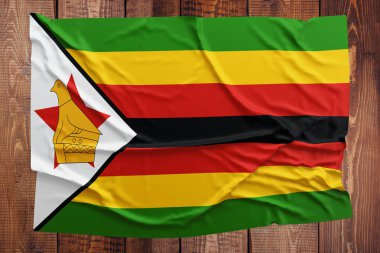Zimbabve bayrağı ahşap masa arka plan üzerinde. Buruşuk Zimbabve bayrağı üstten görünüm.