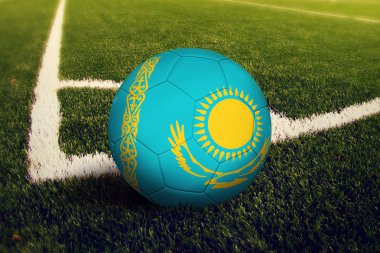 Kazakistan topu köşe vuruşu pozisyonunda, futbol sahası arka planı. Yeşil çimüzerinde ulusal futbol teması.