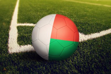 Madagaskar topu köşe vuruşu pozisyonunda, futbol sahası arka planı. Yeşil çimüzerinde ulusal futbol teması.