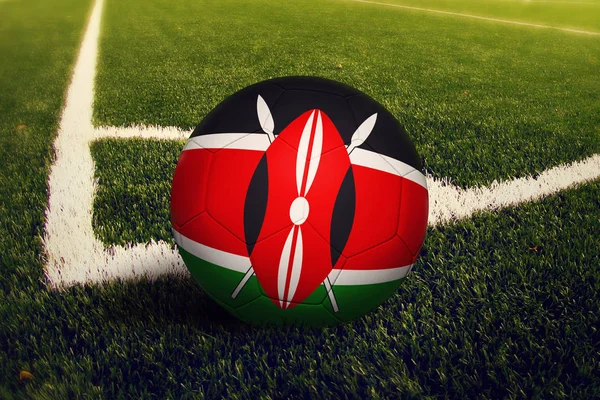 Kenya ball on corner kick position, soccer field background. National football theme on green grass.