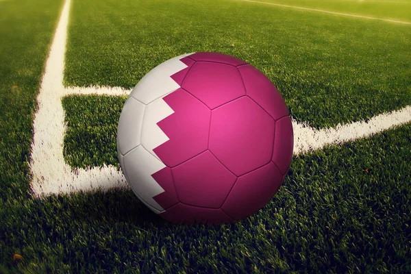 Qatar ball on corner kick position, soccer field background. National football theme on green grass.