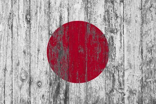 Flag of Japan painted on worn out wooden texture background.