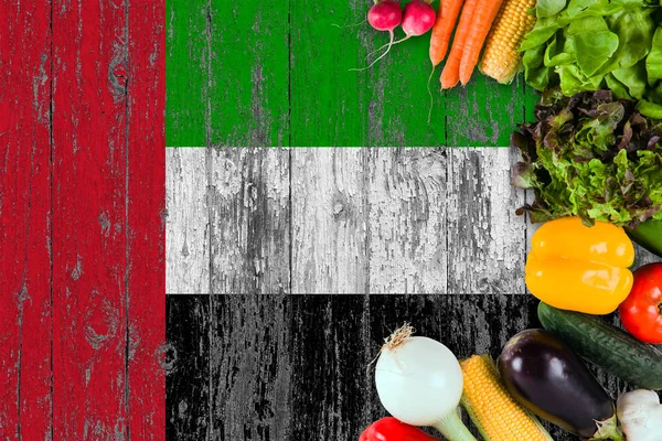 Fresh vegetables from United Arab Emirates on table. Cooking concept on wooden flag background.