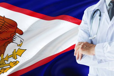 Amerikan Samoası bayrak arka plan üzerinde stetoskop ile ayakta doktor. Ulusal sağlık sisteminin kavramı, tıbbi Tema.