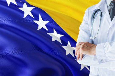 Bosnian Doctor standing with stethoscope on Bosnia Herzegovina flag background. National healthcare system concept, medical theme. clipart