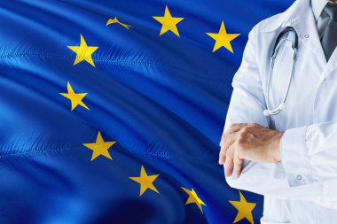 Avrupa Doktor stetoskop Avrupa Birliği bayrağı arka plan üzerinde ayakta. Ulusal sağlık sisteminin kavramı, tıbbi Tema.