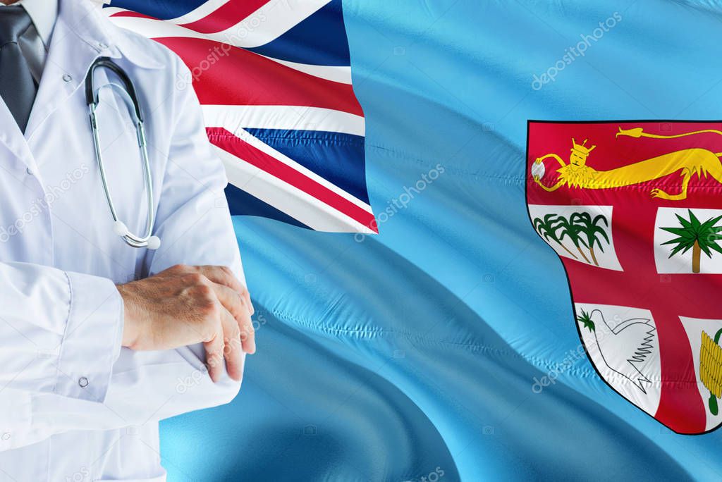 Fijian Doctor standing with stethoscope on Fiji flag background. National healthcare system concept, medical theme.