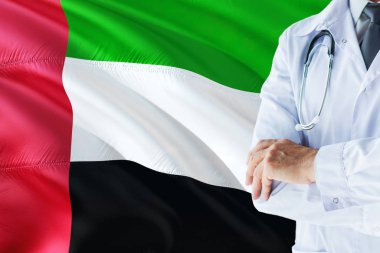 Emirian Doktor stetoskop Birleşik Arap Emirlikleri bayrağı arka plan üzerinde ayakta. Ulusal sağlık sisteminin kavramı, tıbbi Tema.