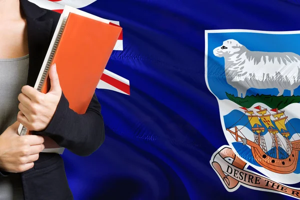 学习语言概念 背景中站着挂着福克兰群岛国旗的年轻妇女 老师拿着书 橙色空白书封面 — 图库照片