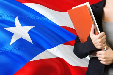 Öğrenme dil kavram. Porto Riko bayrağı arka planda duran genç kadın. Kitaplar, turuncu boş kitap kapağı tutan öğretmen.