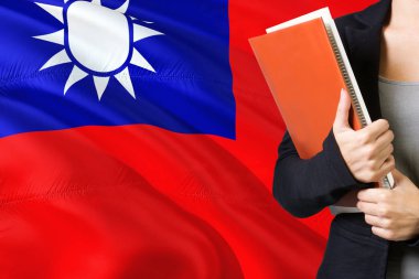 Tayvanlı dil kavram öğrenme. Tayvan bayrağı arka planda duran genç kadın. Kitaplar, turuncu boş kitap kapağı tutan öğretmen.
