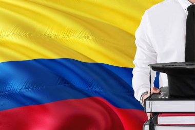 Başarılı Kolombiyalı öğrenci eğitim kavramı. Kolombiya bayrak arka plan üzerinde tutan kitaplar ve mezuniyet kep.