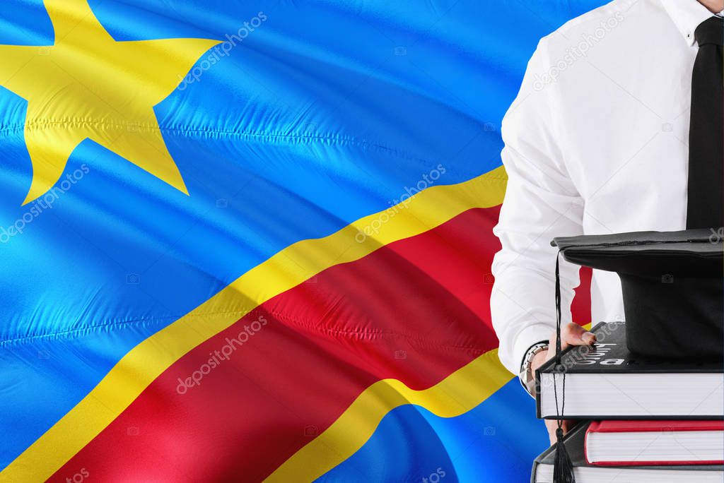 Successful Congolese student education concept. Holding books and graduation cap over Congo flag background.