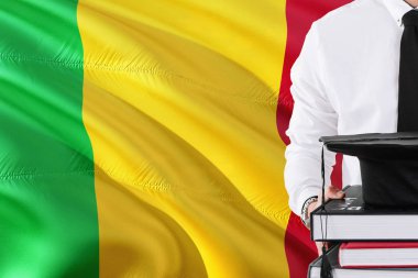 Başarılı Malili öğrenci eğitim kavramı. Elinde kitap ve mezuniyet Mali bayrağı arka plan üzerinde kap.