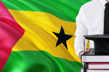 Başarılı öğrenci eğitim kavramı. Sao Tome ve Principe bayrak arka plan üzerinde tutan kitaplar ve mezuniyet kep.