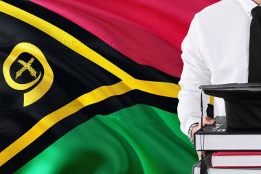 Başarılı öğrenci eğitim kavramı. Vanuatu bayrağını arka plan üzerinde tutan kitaplar ve mezuniyet kep.