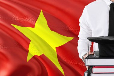 Başarılı Vietnam öğrenci eğitim kavramı. Vietnam bayrağı arka plan üzerinde tutan kitaplar ve mezuniyet kep.